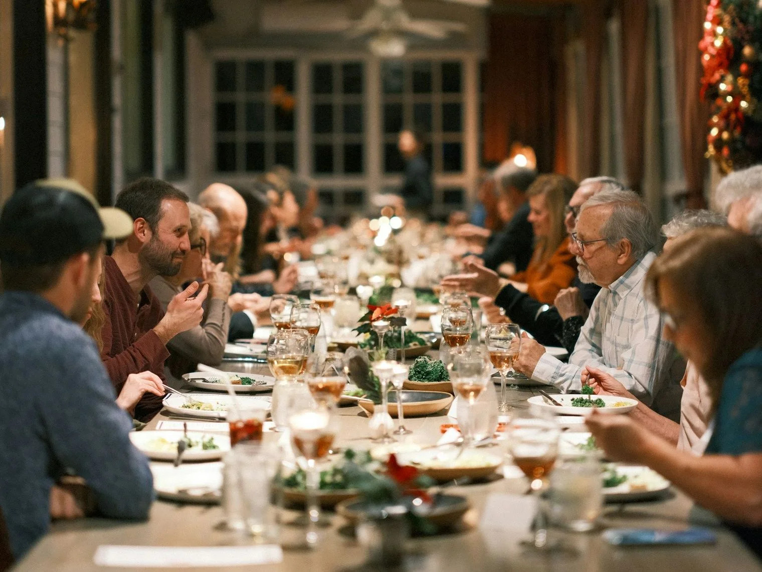 EVERMOORE A large group sharing a meal at a long community table
